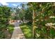 Landscaped backyard walkway with lush plants, flowers, and views of the pool at 1799 Dixie Hwy, Tarpon Springs, FL 34689