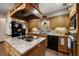 Functional kitchen featuring wood cabinetry, a black appliance package, and an island cooktop at 1799 Dixie Hwy, Tarpon Springs, FL 34689