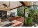 Outdoor patio with a swing, ceiling fan, grill and view of the landscaped backyard at 1799 Dixie Hwy, Tarpon Springs, FL 34689