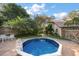 Backyard pool with brick patio, tropical foliage, and comfortable seating area at 1799 Dixie Hwy, Tarpon Springs, FL 34689