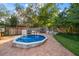 Above-ground pool with brick patio surrounded by a wooden fence and lush tropical foliage at 1799 Dixie Hwy, Tarpon Springs, FL 34689