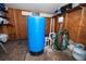 Inside view of utility room featuring water pressure tank, shelving, and water filtration equipment at 1799 Dixie Hwy, Tarpon Springs, FL 34689