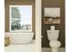 Modern bathroom featuring soaking tub, earthy accents, tile floor, and stylish fixtures at 18136 Serene Lake Loop, Lutz, FL 33548