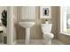 Elegant half bathroom featuring neutral tones, white fixtures, and a bright window at 18136 Serene Lake Loop, Lutz, FL 33548