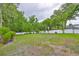 Expansive backyard featuring a well-maintained lawn, mature trees, and a pristine white fence at 18444 Eastwyck Dr, Tampa, FL 33647