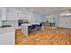 Open-concept kitchen featuring a large island, white cabinets, stainless steel appliances, and modern lighting at 18444 Eastwyck Dr, Tampa, FL 33647