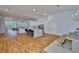 Bright kitchen with white cabinets, a center island with seating, and hardwood floors leading to the living area at 18444 Eastwyck Dr, Tampa, FL 33647