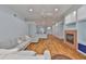 Spacious living room featuring a cozy sectional sofa, fireplace, and hardwood floors at 18444 Eastwyck Dr, Tampa, FL 33647