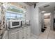 View of the kitchen with microwave and a glimpse of the bathroom at 19029 Us Highway 19 N # 5-16, Clearwater, FL 33764