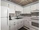 View of the kitchen featuring white cabinets, tile floors, and modern appliances at 19029 Us Highway 19 N # 5-16, Clearwater, FL 33764