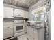 View of the kitchen with white cabinets and appliances with a window overlooking the complex at 19029 Us Highway 19 N # 5-16, Clearwater, FL 33764