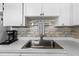 Close-up of the kitchen sink and cabinets with backsplash and hardware at 19029 Us Highway 19 N # 5-16, Clearwater, FL 33764