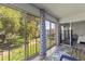 Enclosed porch features a blue outdoor chairs with views of green lawn and landscaping at 19029 Us Highway 19 N # 5-16, Clearwater, FL 33764