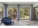 Enclosed porch has a blue chair and rug with backyard views and sliding glass doors at 19029 Us Highway 19 N # 5-16, Clearwater, FL 33764