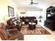 Inviting living room featuring comfortable leather furniture, decorative wall art, and large windows at 19420 Haskell Pl, Land O Lakes, FL 34638