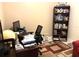 This home office includes a desk, office chair, rug and a full bookshelf at 19420 Haskell Pl, Land O Lakes, FL 34638