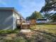 Back deck with wood railings and stairs to a partially shaded lot at 21033 Market St, Dade City, FL 33523