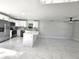 Open-concept kitchen with white cabinets, stainless steel appliances, and view of living area at 21033 Market St, Dade City, FL 33523
