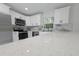 Modern kitchen features white cabinets, stainless steel appliances, quartz counters, and marble backsplash at 21033 Market St, Dade City, FL 33523