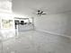 Contemporary living room featuring white tile floors, neutral walls, and a seamless flow into the kitchen area at 21033 Market St, Dade City, FL 33523