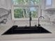Modern, black, farmhouse style sink with stainless steel faucet in kitchen with window at 21033 Market St, Dade City, FL 33523