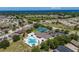 Aerial view showcases community pool and tennis courts with surrounding well-maintained homes and tropical landscaping at 2614 Hawk Roost Ct, Holiday, FL 34691