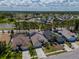 Aerial view of a neighborhood with houses and landscaping with nearby lakes at 2614 Hawk Roost Ct, Holiday, FL 34691