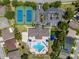 Top-down aerial view showcases community amenities including tennis courts, parking, pool, and meticulously maintained landscaping at 2614 Hawk Roost Ct, Holiday, FL 34691