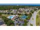 Community aerial view showcasing pool and tennis courts surrounded by lush greenery and well-maintained homes at 2614 Hawk Roost Ct, Holiday, FL 34691