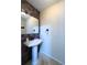 Stylish powder room with pedestal sink, decorative wall tiles, and modern fixtures at 2614 Hawk Roost Ct, Holiday, FL 34691