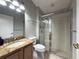 Well-lit bathroom with a tiled glass shower, granite countertop, and a mirror at 2614 Hawk Roost Ct, Holiday, FL 34691
