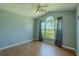 Serene bedroom with a ceiling fan, wood floors, and a window with views of trees at 2614 Hawk Roost Ct, Holiday, FL 34691