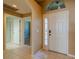 Bright foyer with tile flooring, a view to the bathroom and bedroom, and an elegant entry door at 2614 Hawk Roost Ct, Holiday, FL 34691