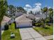 Well-maintained single-Gathering home with a two-car garage, landscaped yard, and a neatly kept lawn at 2614 Hawk Roost Ct, Holiday, FL 34691