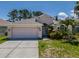 Lovely single-Gathering home featuring a two-car garage, arched entry, and manicured landscaping at 2614 Hawk Roost Ct, Holiday, FL 34691