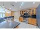 Well-lit kitchen with stainless steel appliances, wood cabinetry, and black granite countertops at 2614 Hawk Roost Ct, Holiday, FL 34691