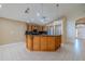 Open-concept kitchen has stainless appliances, bar seating and glass front cabinets at 2614 Hawk Roost Ct, Holiday, FL 34691