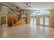 Bright living room featuring a staircase and large windows that provide plenty of natural light at 2614 Hawk Roost Ct, Holiday, FL 34691
