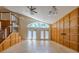Sunlit living room with wood-paneled walls, high ceilings, and French doors at 2614 Hawk Roost Ct, Holiday, FL 34691