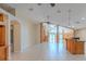 Bright, open-concept living area with tile flooring, ceiling fans, and staircase at 2614 Hawk Roost Ct, Holiday, FL 34691