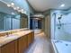 Large main bathroom featuring a jetted tub, glass shower and double sinks at 2614 Hawk Roost Ct, Holiday, FL 34691