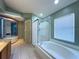 Luxurious main bathroom featuring a jetted tub and glass shower at 2614 Hawk Roost Ct, Holiday, FL 34691