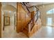 Grand staircase with light wood and glass paneling leading to the upper floor at 2614 Hawk Roost Ct, Holiday, FL 34691