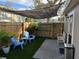 Inviting backyard with artificial turf, shade cover, bistro lights, patio seating, and wooden fence at 2745 4Th S Ave, St Petersburg, FL 33712