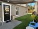 Cozy backyard with artificial grass, shaded seating area, string lights, and black trimmed door at 2745 4Th S Ave, St Petersburg, FL 33712