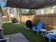 Charming backyard with artificial grass, blue Adirondack chairs, string lights, and shade cover at 2745 4Th S Ave, St Petersburg, FL 33712