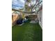 Manicured backyard with artificial grass, grill, privacy fence, seating, and a shade cover at 2745 4Th S Ave, St Petersburg, FL 33712