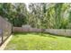 A lush backyard is pictured with green grass, a wood fence, a shed, and mature trees at 2818 Cedaridge Dr, Tampa, FL 33618