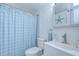 Bathroom features a toilet, sink, shower with a blue curtain and decor at 2818 Cedaridge Dr, Tampa, FL 33618