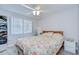 Comfortable bedroom with floral bedding, a ceiling fan, and a large window for natural light at 2818 Cedaridge Dr, Tampa, FL 33618